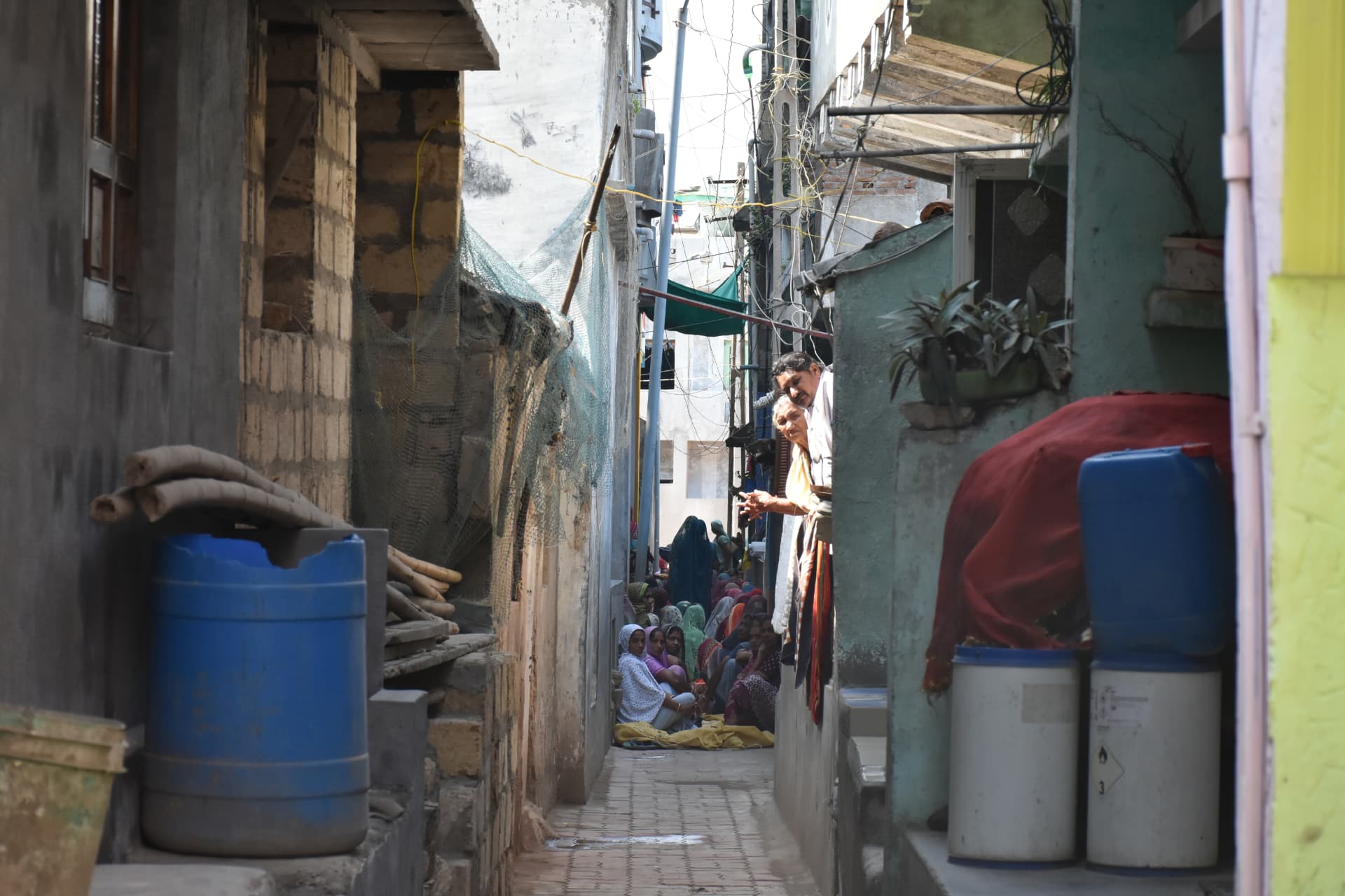 A narrow lane in a fishing settlement with families gathered