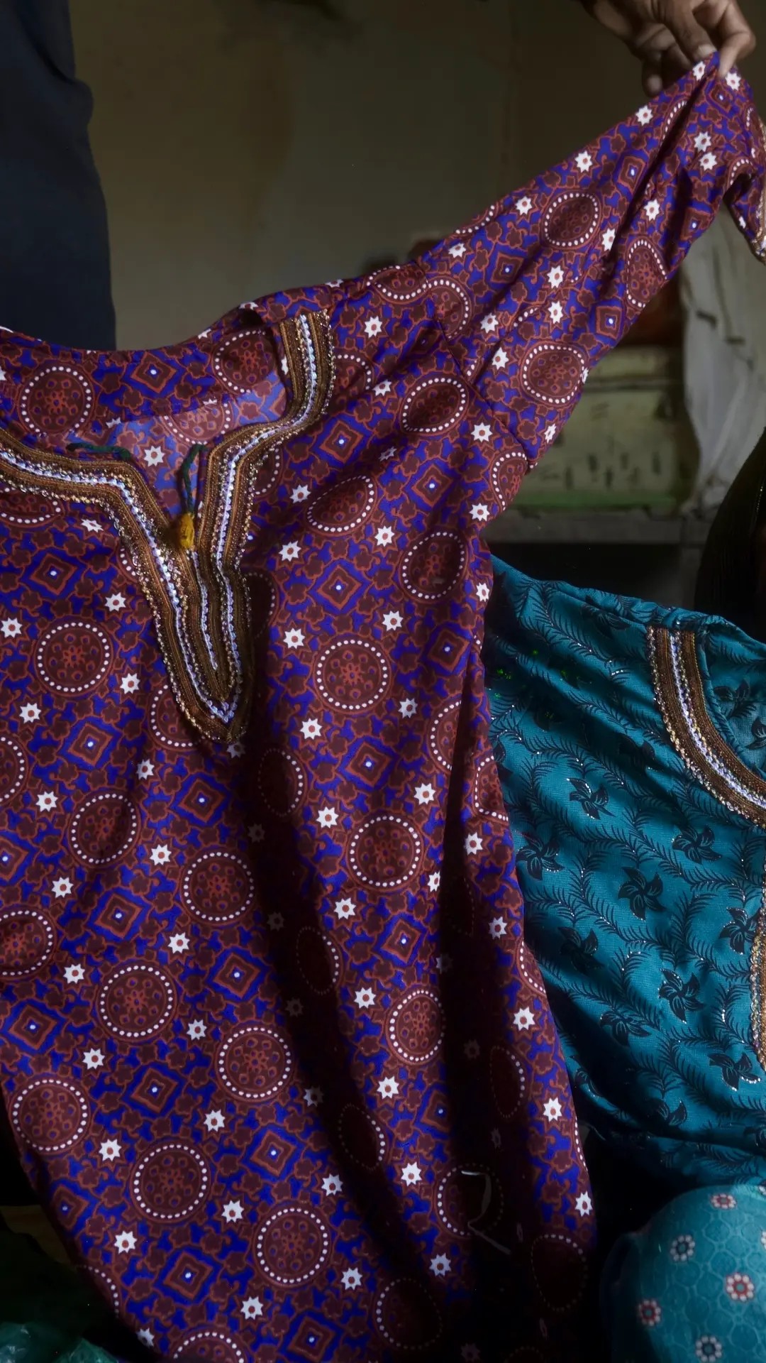 Hands holding up block-printed cloth