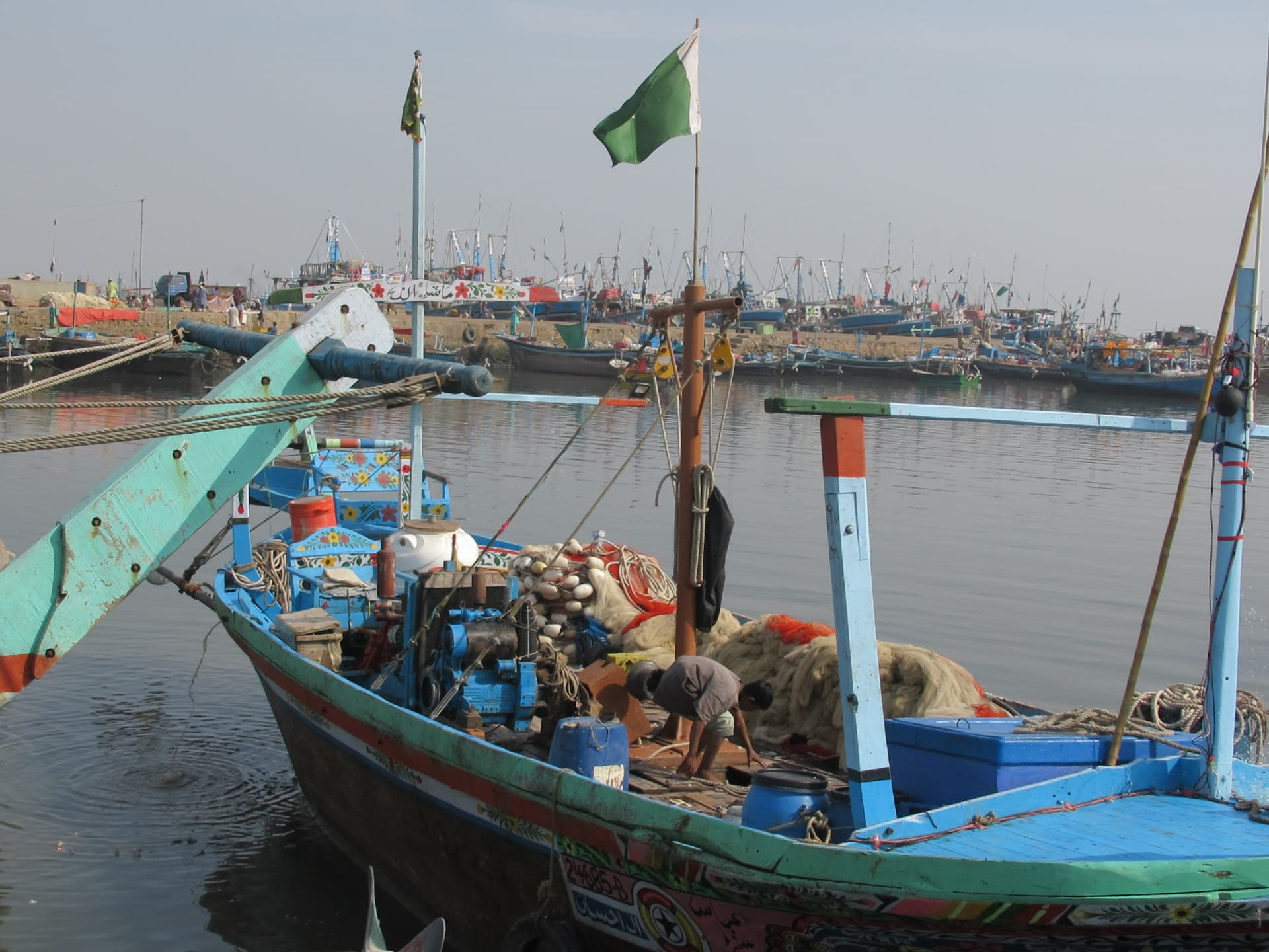 A fisherman working on a moored boat near Seer Creek