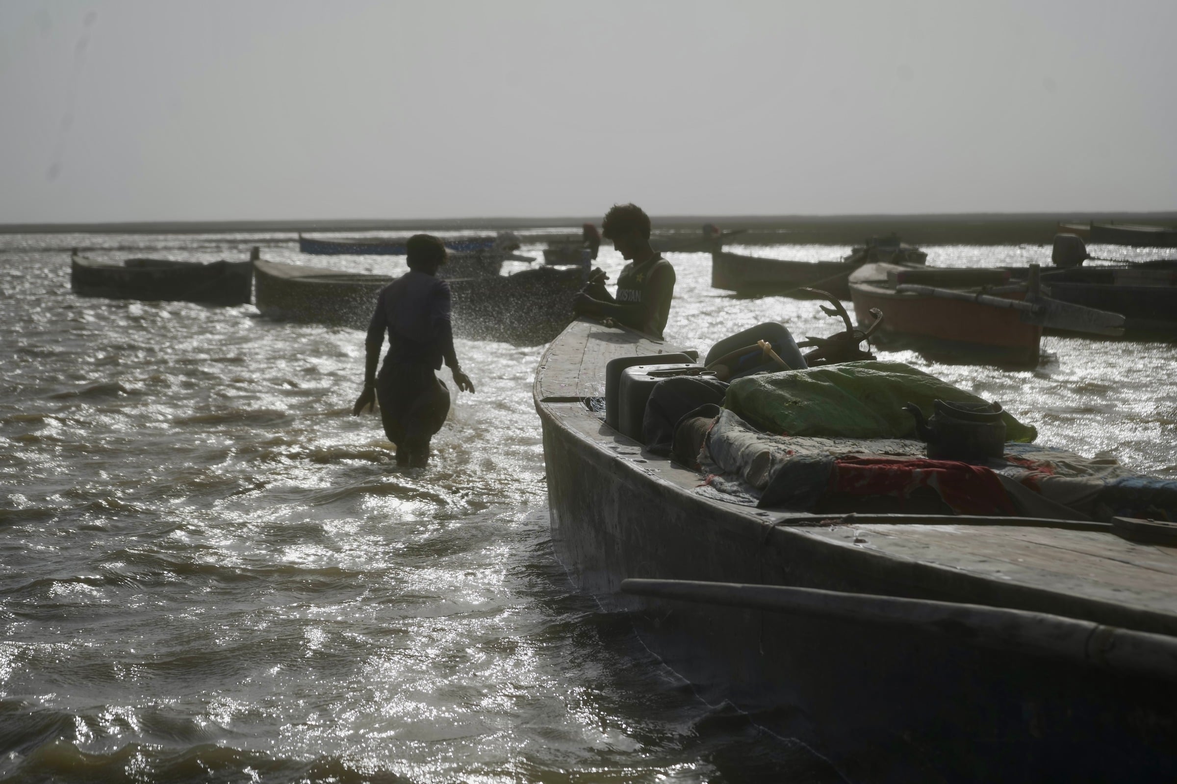 Fishermen pushing a boat out through the surf
